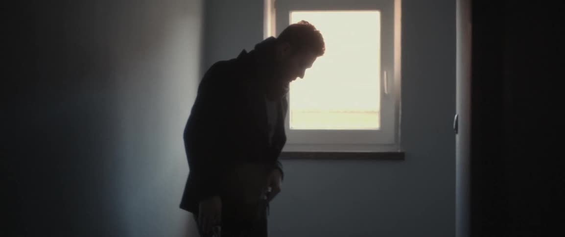 A man turns around and leans against the wall