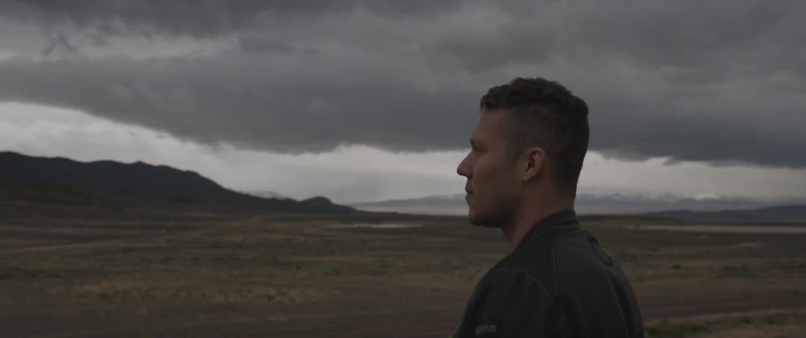 Man standing on an open plain on a very cloudy day