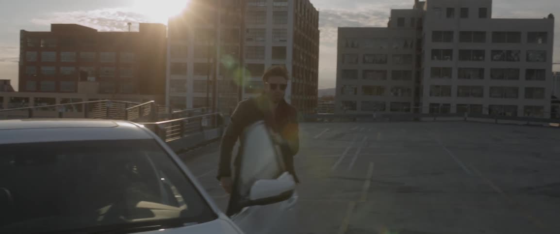 A man gets out of a car on a rooftop