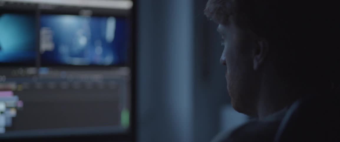 A man is looking towards a monitor