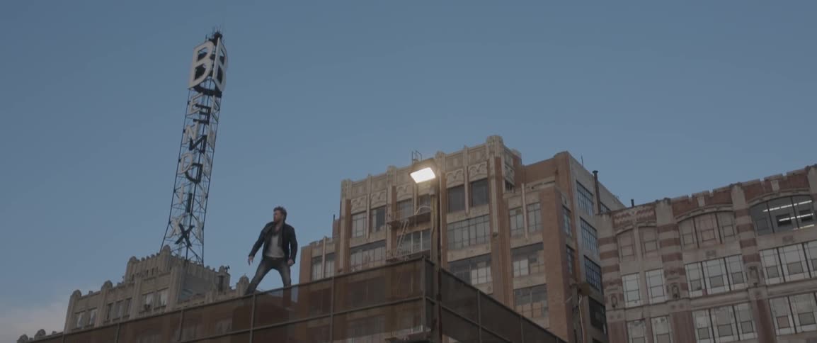 A man stands on a roofed fence