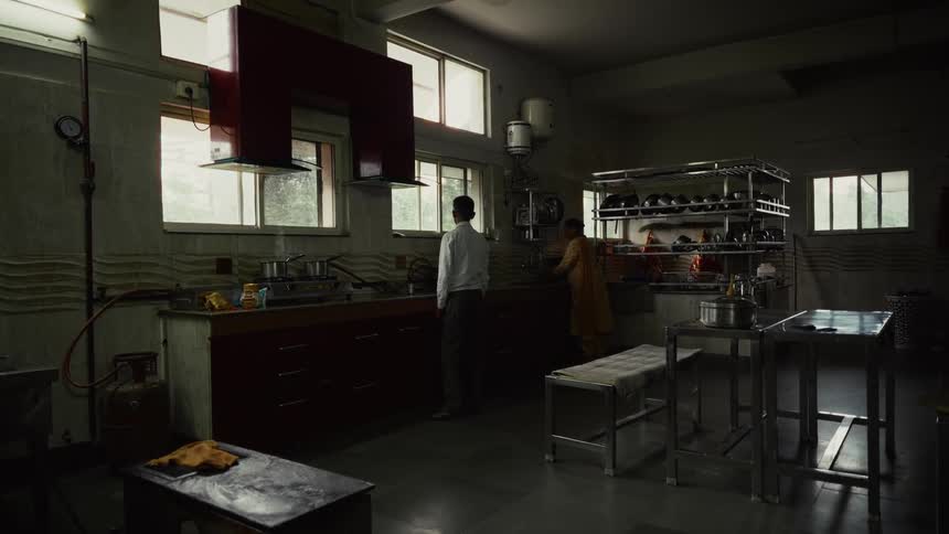 Simple industrial kitchen with two people working near the counter