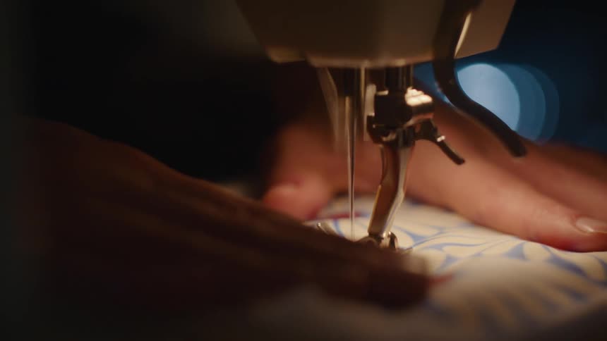 A woman is using a sewing machine on a piece of fabric