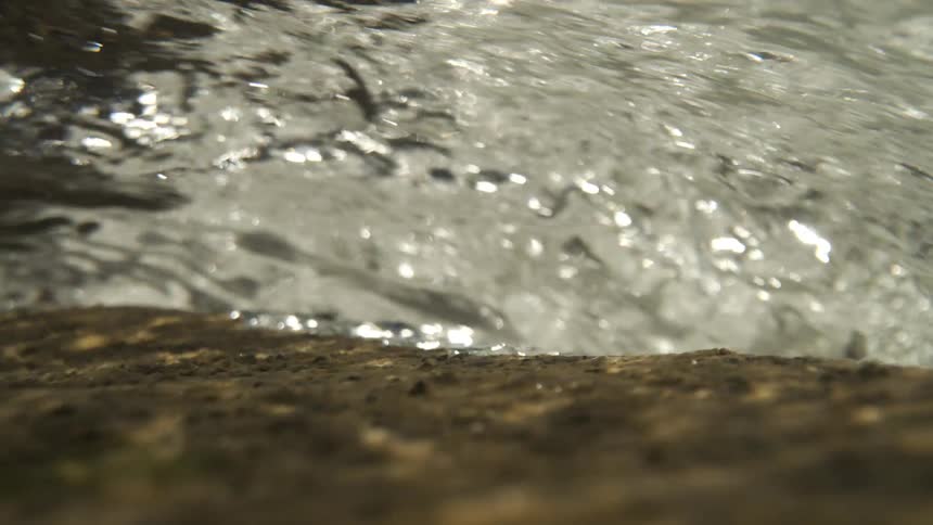 High speed river water showing flow over a small waterfall underwater