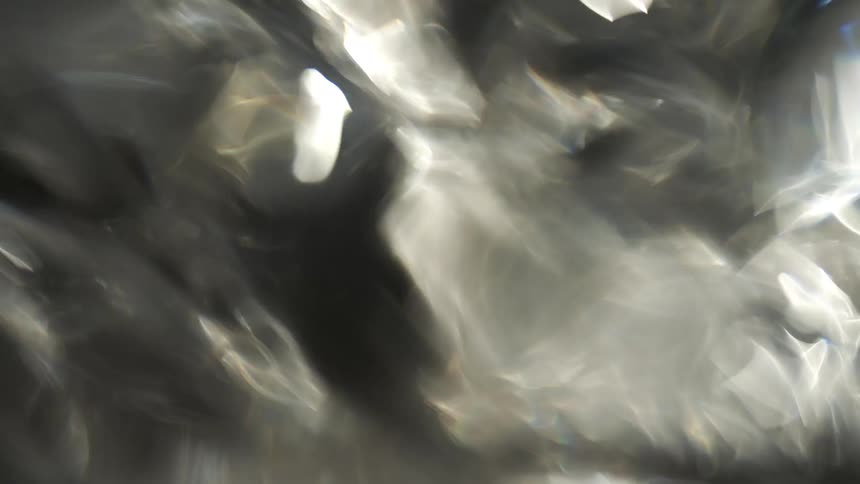 Blurred shimmering reflections suggest water flowing under diffuse light