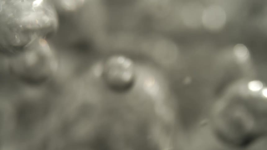 An abstract bright gray background with light reflections on a liquid and distorted flowing shapes