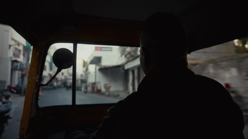 Urban view unfolds through rickshaw windshield