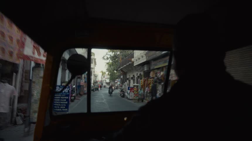 Small vehicles travel down the long alley in the city