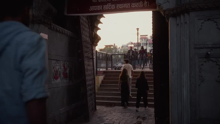 Group passes through traditional gateway with hindi welcome at dusk