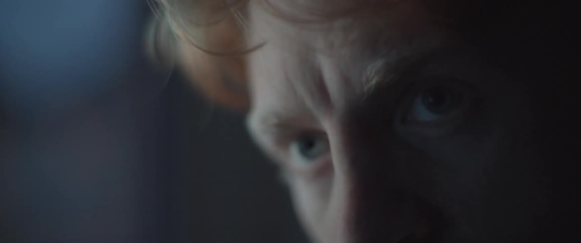 A man in the dark with lights flashing in his face