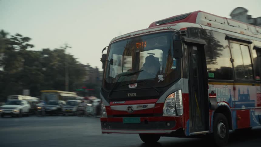 City bus travels along a busy avenue at dusk