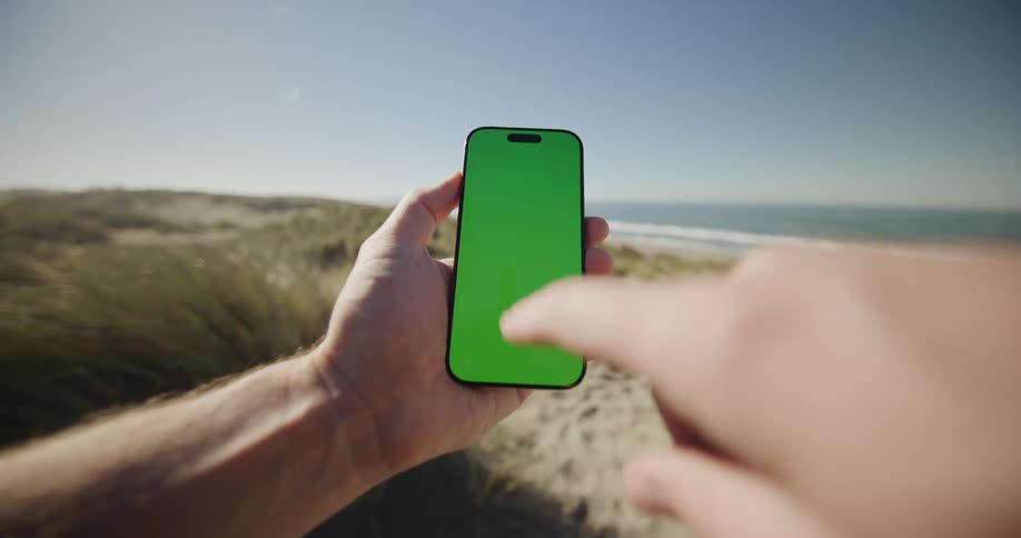 Person interacts smartphone facing the sea