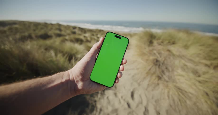Close up of a person displaying a mobile phone in their palms while standing at the beach during daytime
