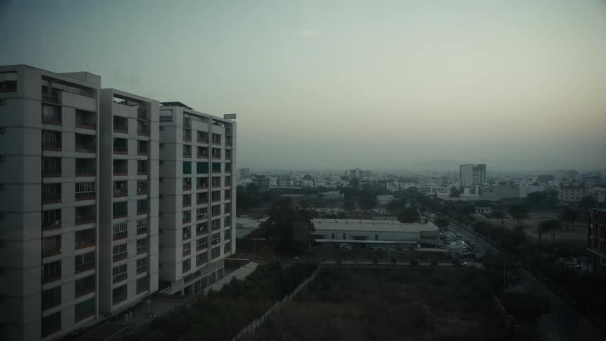 A highrise condo building stands in the city at sunset