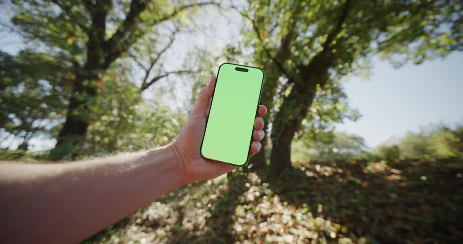 A person holding a smartphone outdoors