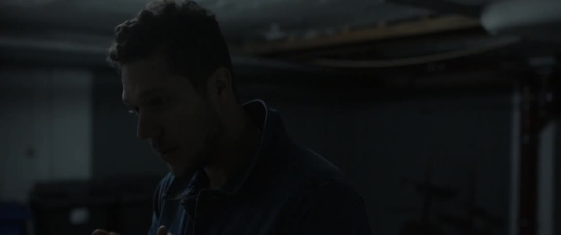 A man blows on his hands at night