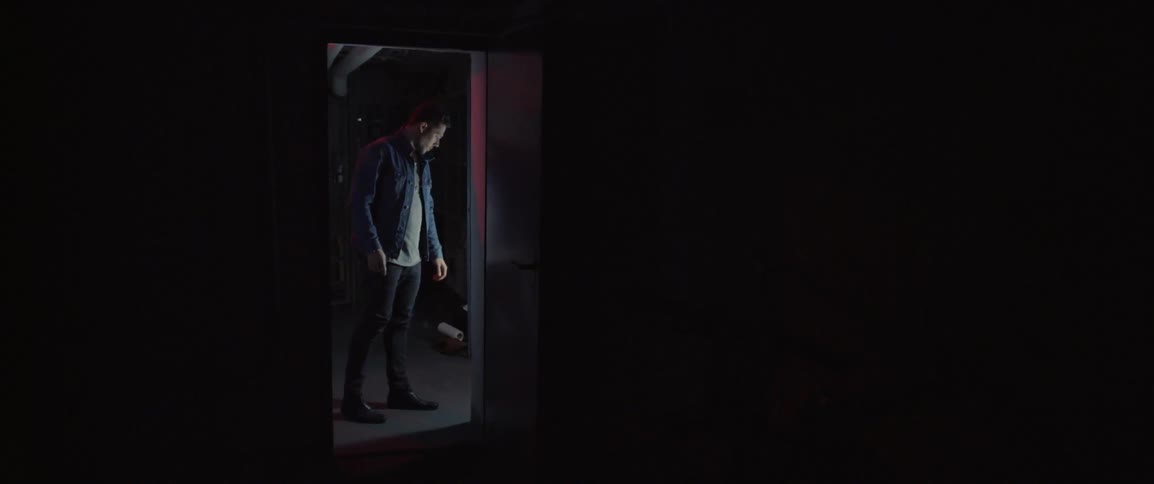 A man walks into a doorway and exams the area surrounding it