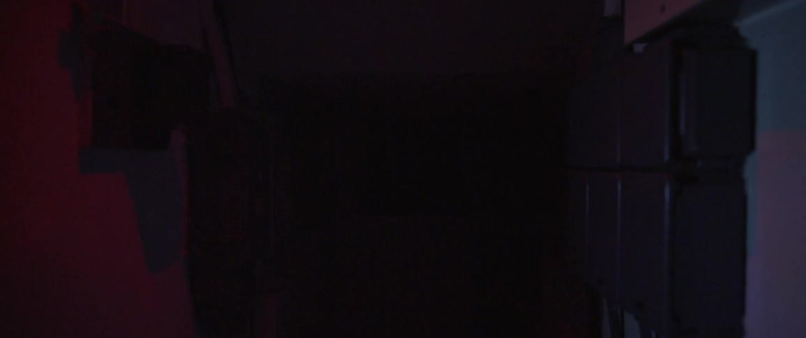 A light flashes on and off in a dark room