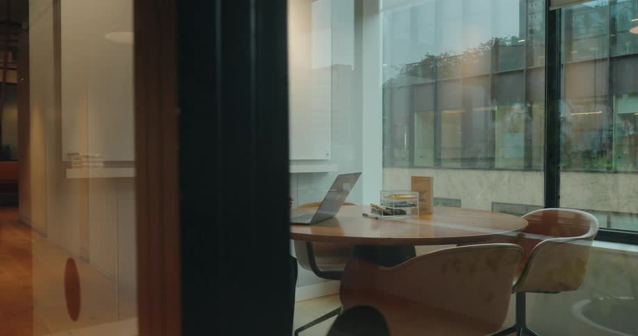 Young asian woman sitting on a chair using a laptop over a table on an office indoors during day time
