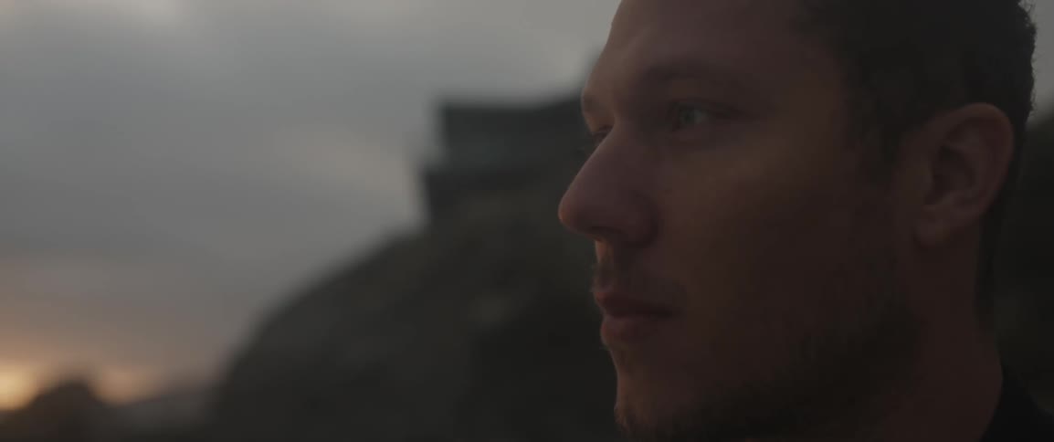 A man looks out over a sunset