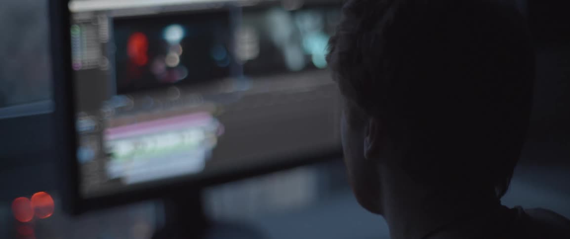 A man looks at a computer monitor