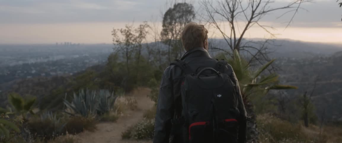 Man wearing a backpack walks in nature