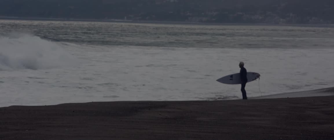 A man walks in the water near the ocean