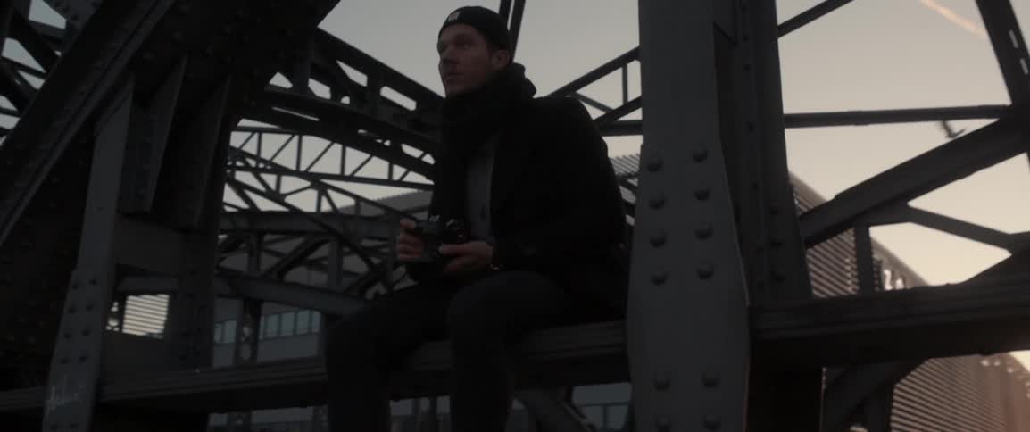 A man is sitting on a scaffolding by a station