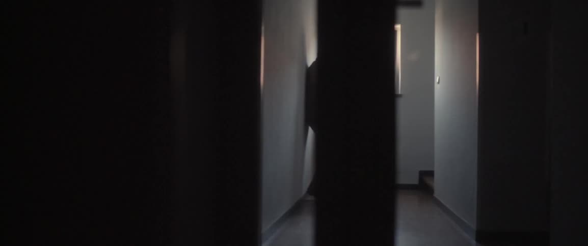 A man standing in a hallway by a window,