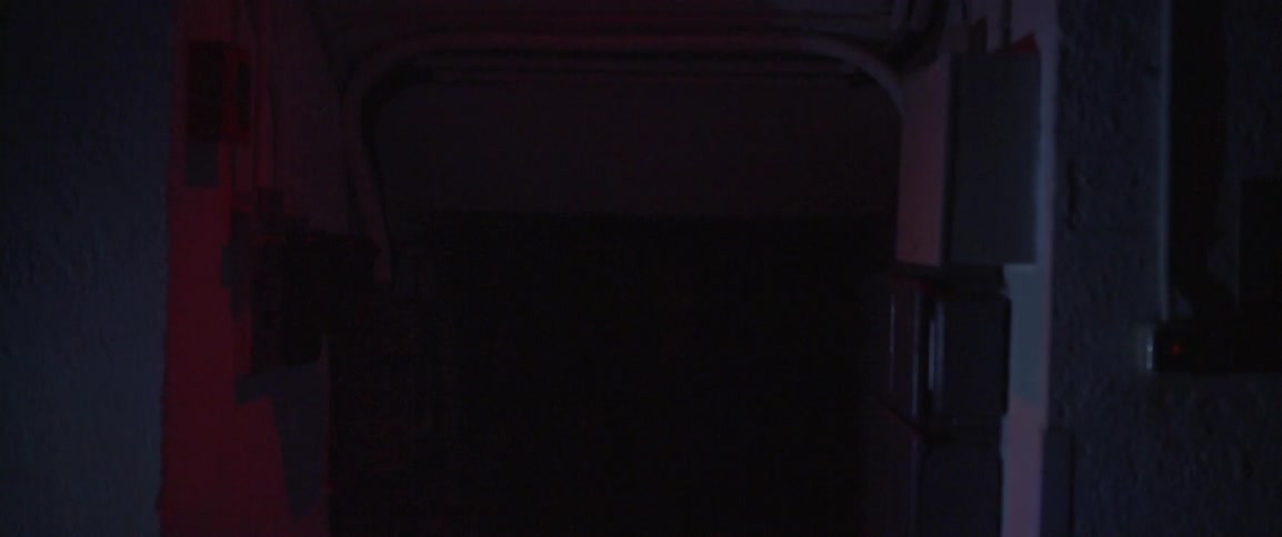 A man walks down a dark hall