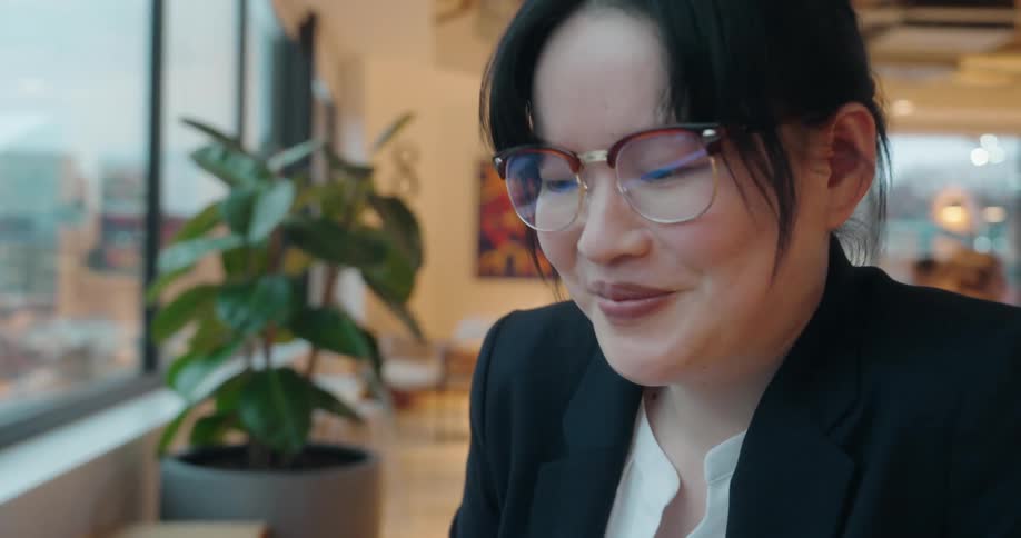 A woman works on a laptop in a modern well lit office