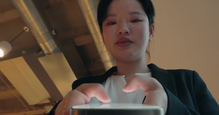 A woman is looking down texting on her phone