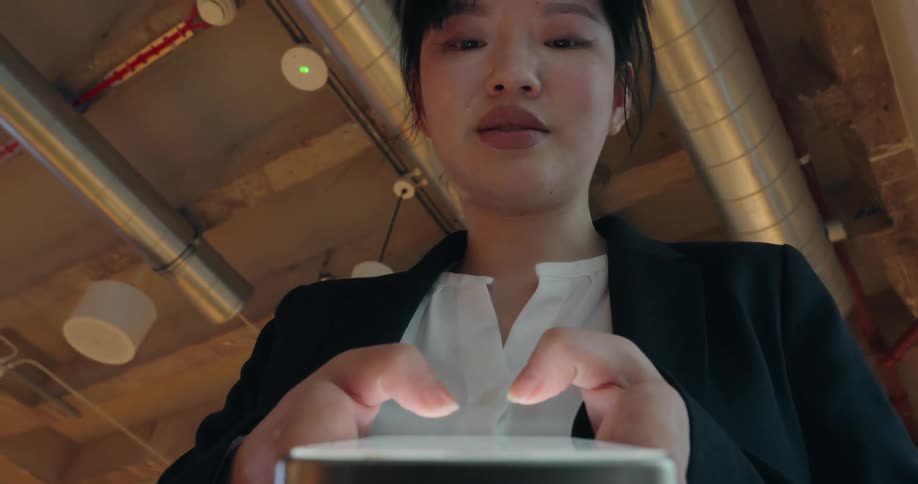 A woman typing on a smartphone