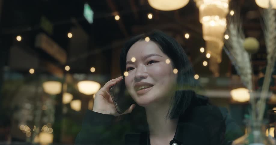 The woman behind the glass talks on her phone