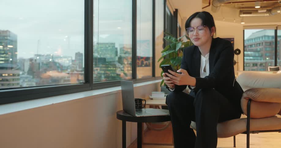 A woman sitting in an office using a phone