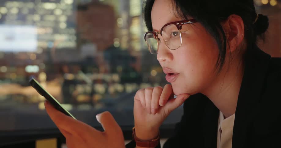 Woman holding her phone and texting with her thumbs