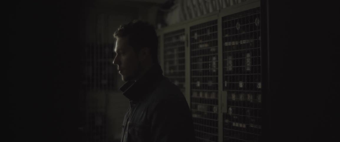 A man looks around in a dark room