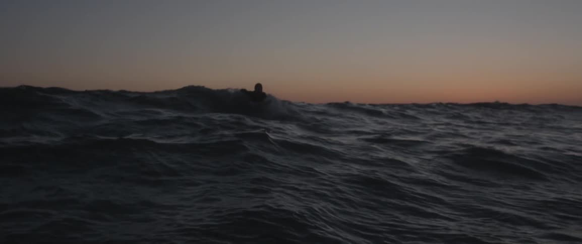 The waves crash and move around as a man surfs on them