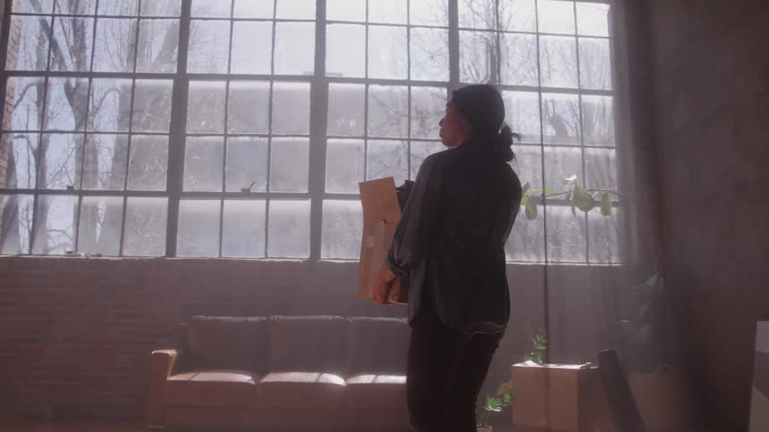 The woman is moving her boxes into a new home