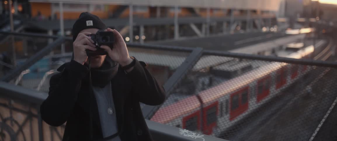 Man taking a picture on a bridge in the city