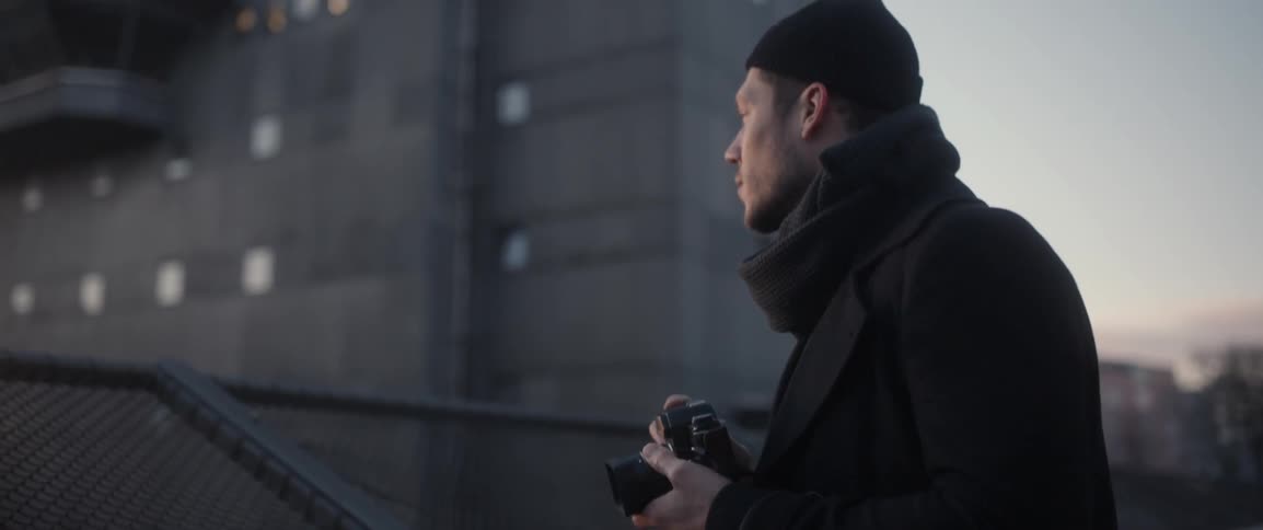 A man takes a photograph in an urban setting