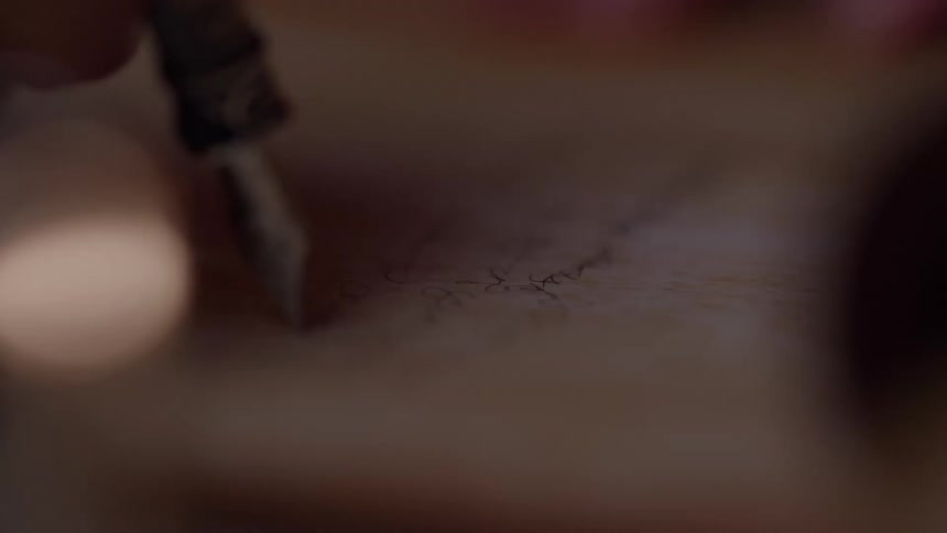 The man is writing with a fountain pen