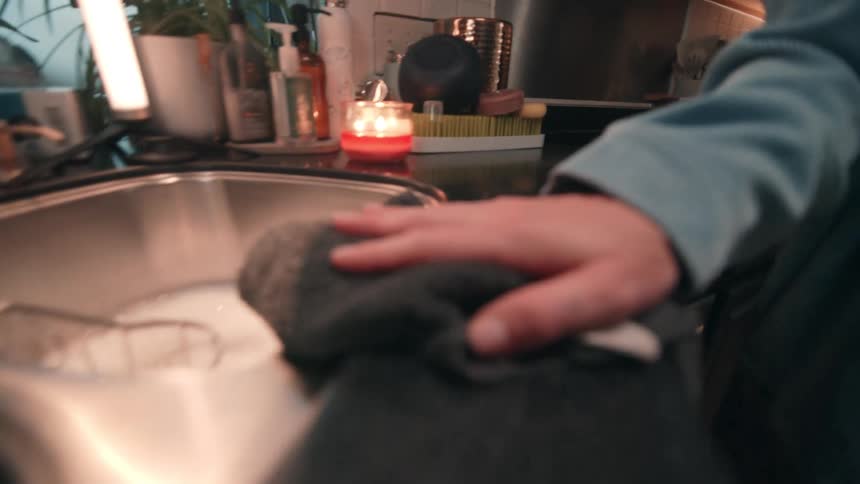 The woman cleans the counter with a rag