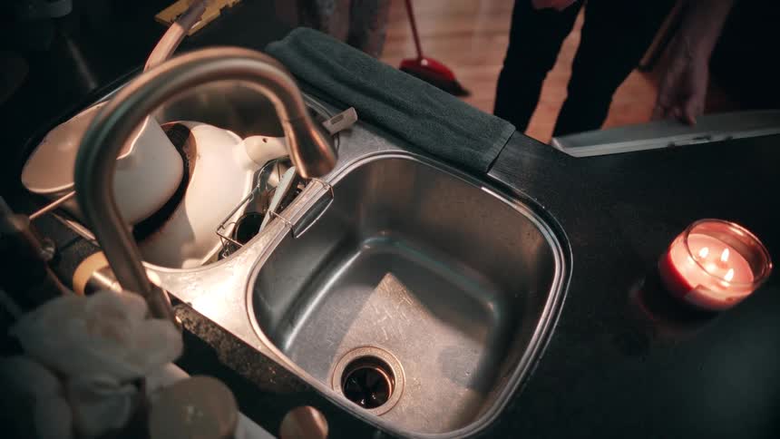 Two people interacting with utensils in the kitchen