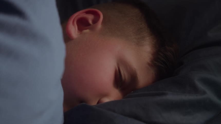 A child sleeping peacefully on his bed