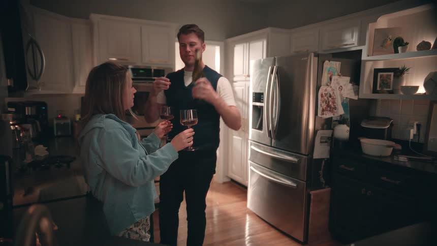 Couple toasting and drinking wine in the kitchen