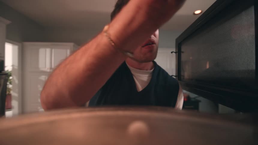 Man wipes the microwave door inside the kitchen