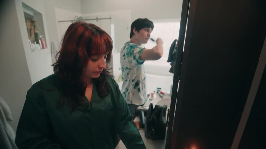 The man brushes his hair and uses hairspray