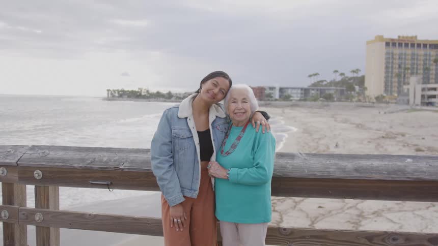 Grandmother and granddaughter hug on the pier