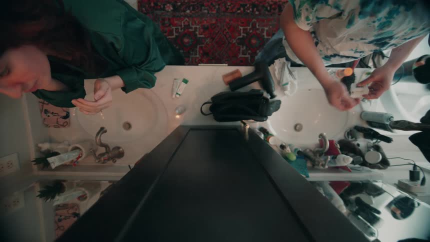 A young man and woman preparing together in the bathroom